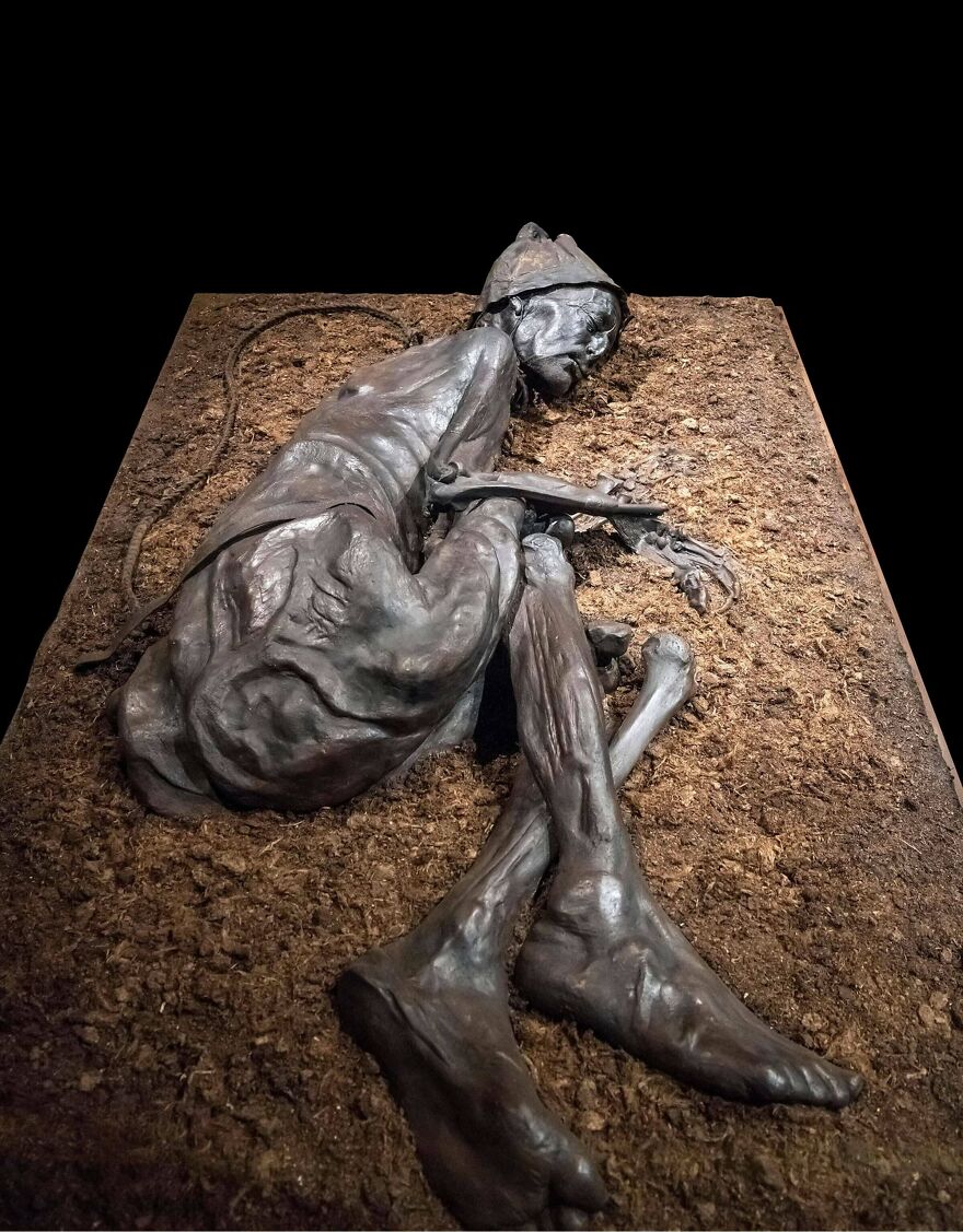 Bronze sculpture of a skeletal figure curled up on dirt, illustrating one of the random pictures worth exploring deeply.