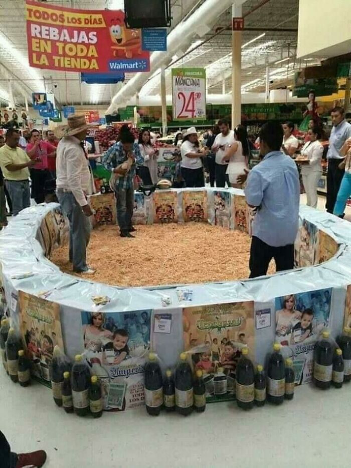 Walmart store scene with people gathered around a large ring filled with wood shavings inside the store aisle.