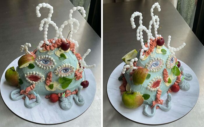 Surreal masterfully crafted cake decorated with fruit, intricate frosting designs, and artistic facial features on a round board.