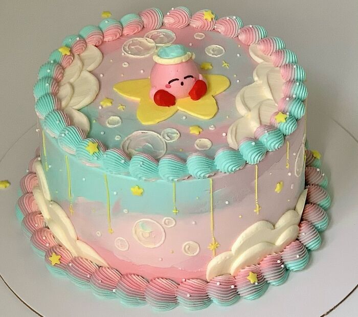Pastel-colored masterfully crafted cake with cartoon character and star decorations showcasing creativity.
