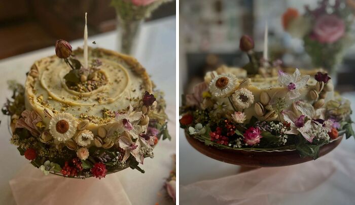 Masterfully crafted cake decorated with intricate edible flowers and nuts, showcasing creativity in cake design and artistry.