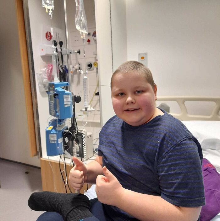 Child in hospital room smiling and giving thumbs up, a heartwarming photo that will make your day feel lighter
