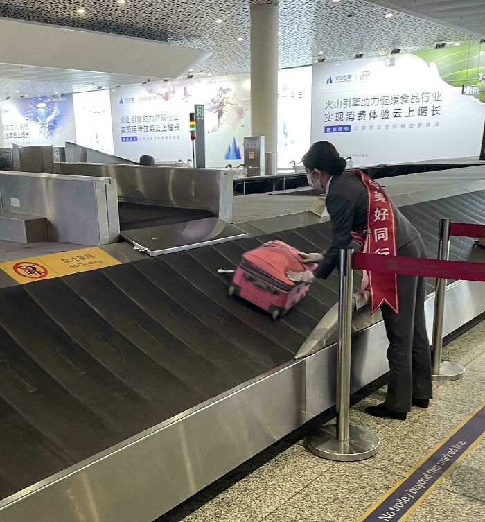 Airport worker managing luggage on conveyor belt, showcasing different jobs that make a 9-to-5 more bearable.