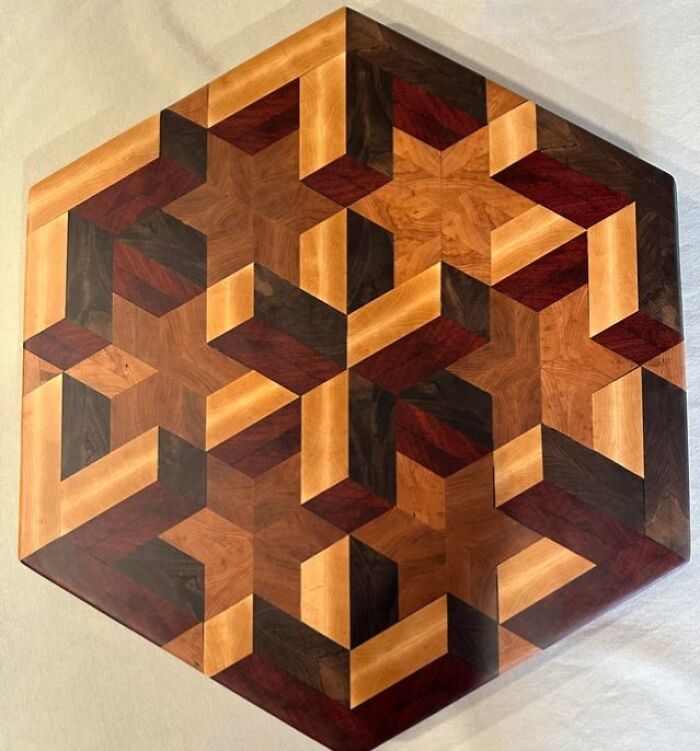 Intricate woodworking project featuring a geometric hexagonal pattern with various shades of carved wood pieces.
