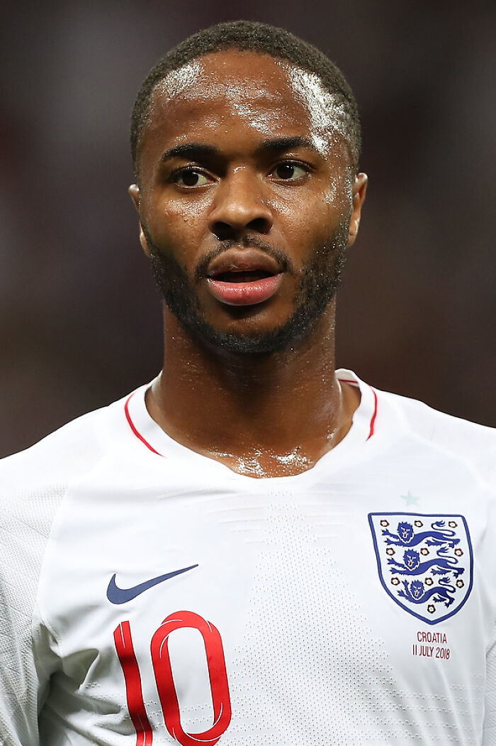 Raheem Sterling in England football jersey, focused during a match, showcasing key moments in his career.