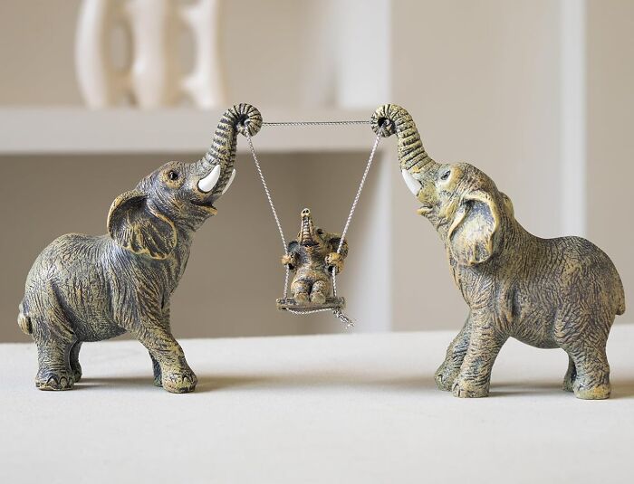 Decorative elephant figurines holding a swing with a baby elephant, perfect gifts for the teacher with patience and caffeine love.