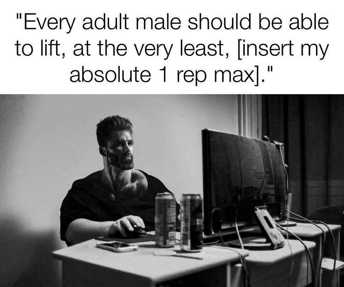 Man with muscular build sitting at desk with computer, emphasizing strength and relatable gym memes for lifters.