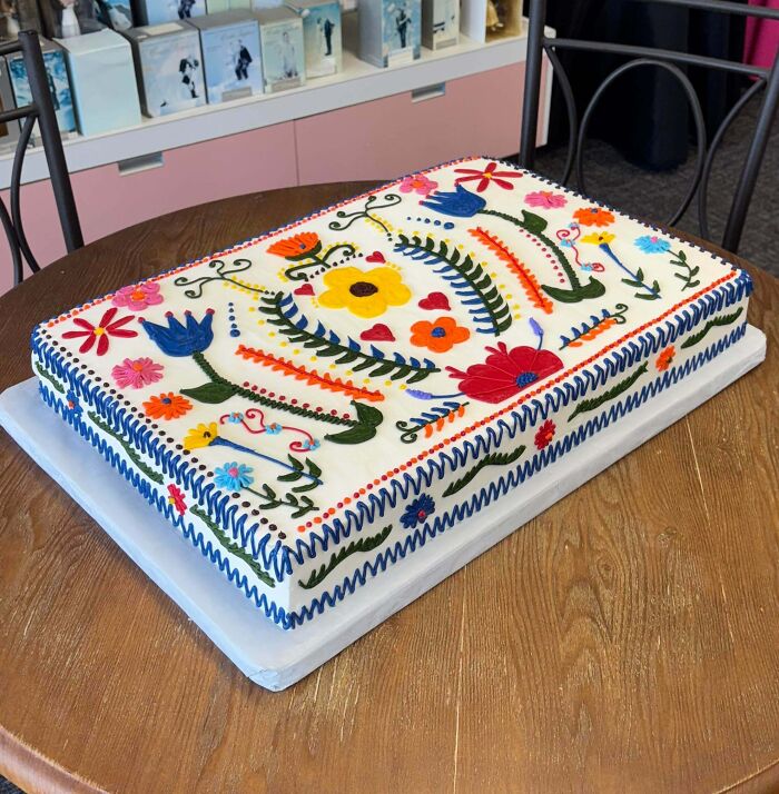 Rectangular cake decorated with colorful floral designs and intricate piping showcasing masterfully crafted cake creativity.