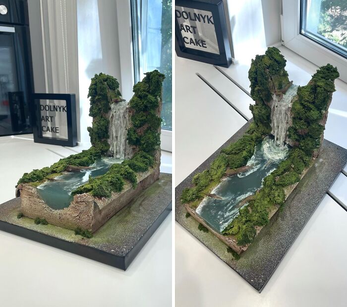 Masterfully crafted cake shaped like a scenic waterfall with lush green moss and flowing water details on a display table.