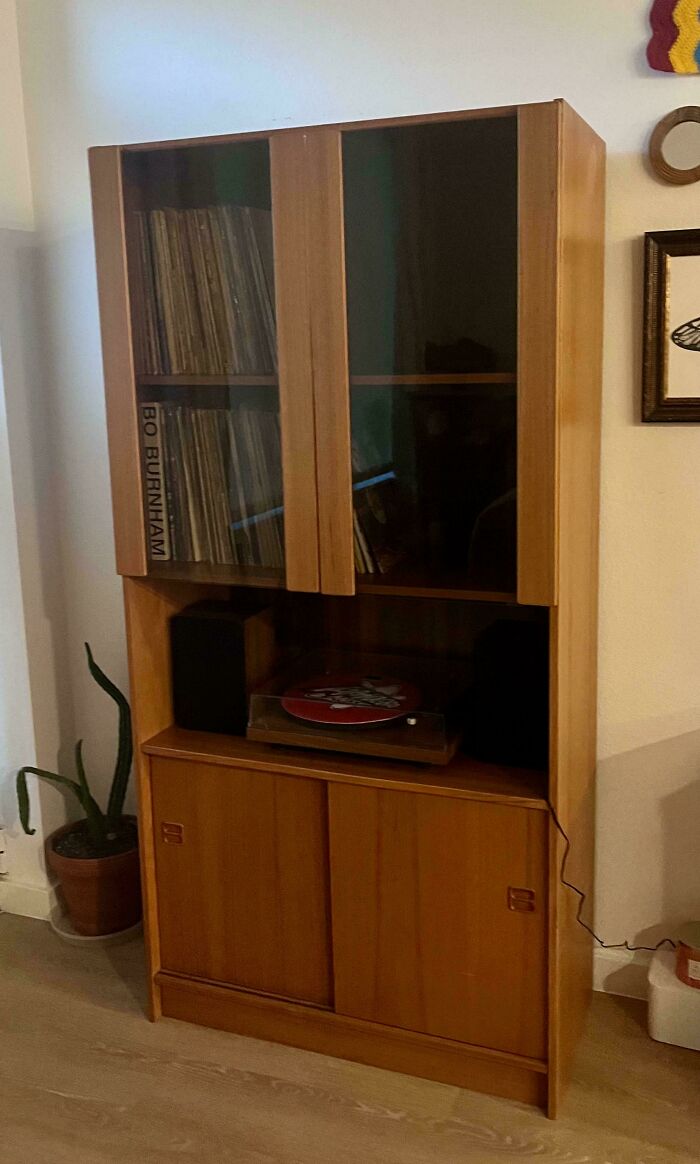 Vintage wooden cabinet with vinyl records and record player showing cool secondhand store surprises.