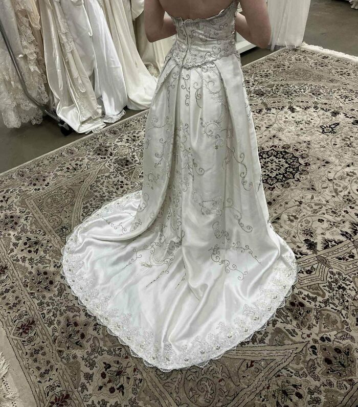 Person wearing an elegant embroidered wedding dress found in a secondhand store with cool, unexpected surprises visible.