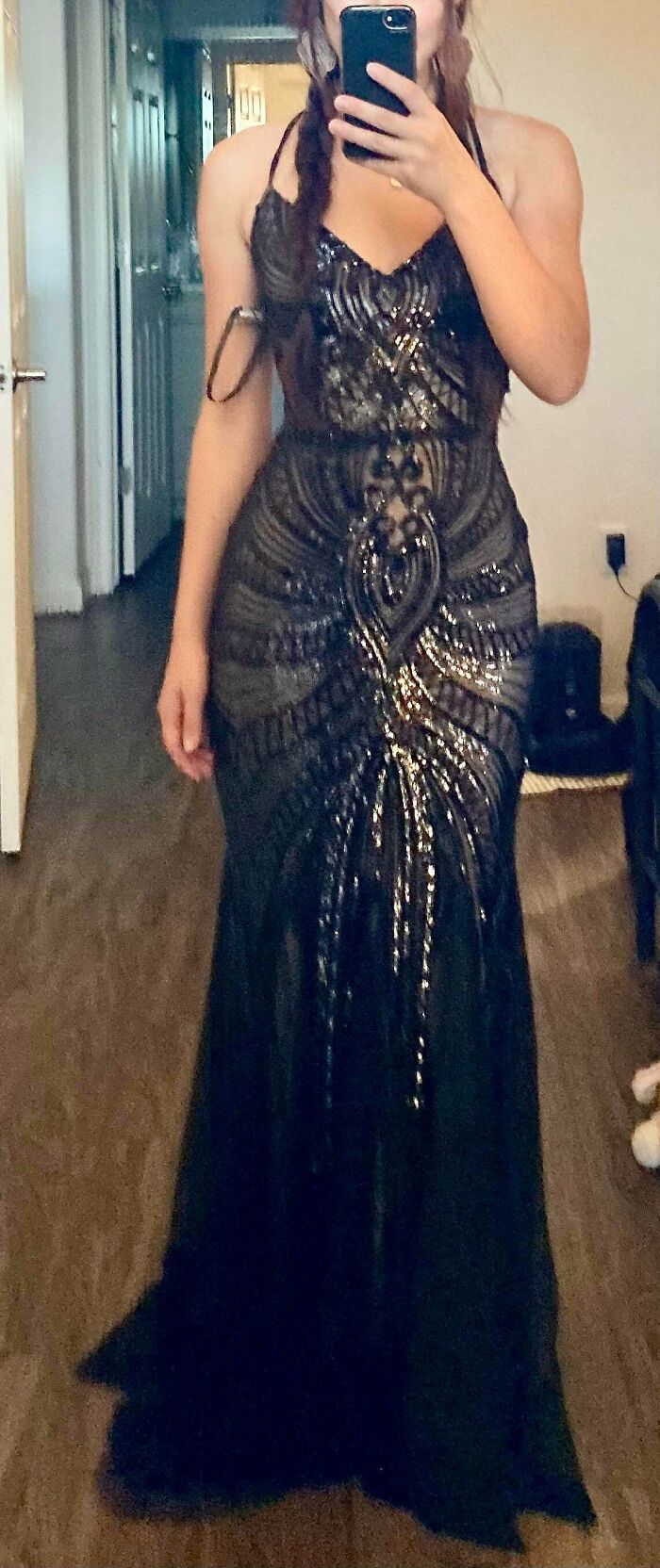 Woman wearing a black formal gown with intricate beaded patterns found at a secondhand store surprise.