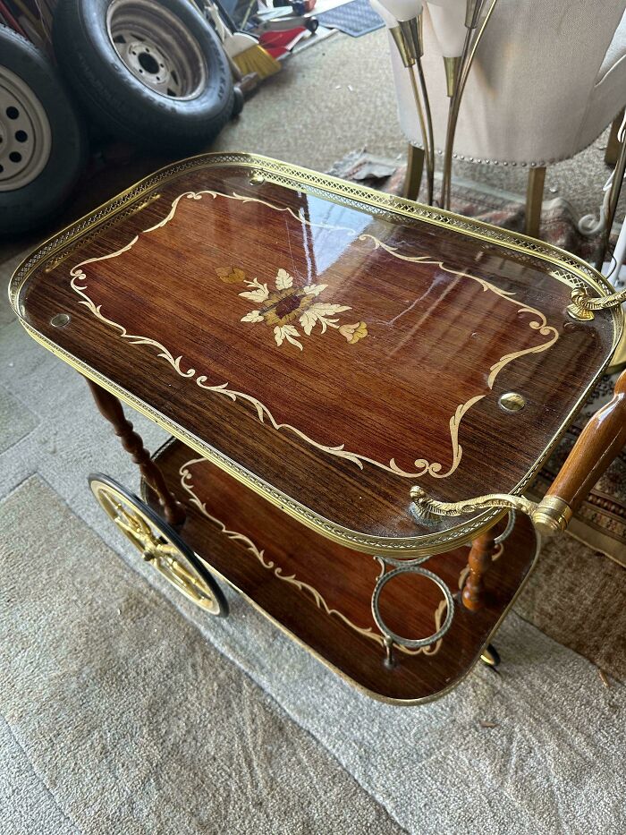 Vintage wooden bar cart with brass accents and floral inlay found in a secondhand store as a cool, unexpected surprise