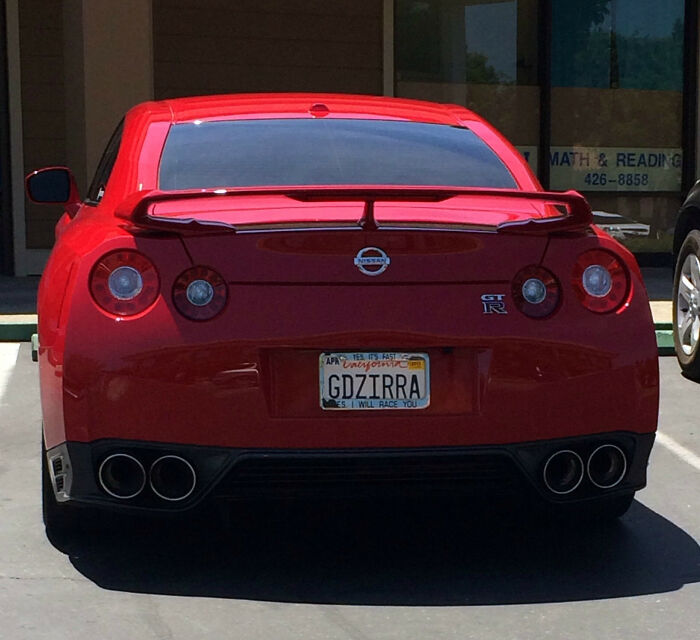 Red Nissan GT-R parked with a hilarious personalized license plate reading GDZIRRA causing double takes.