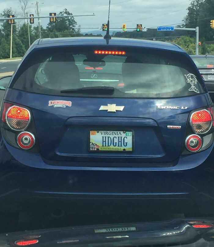 Blue Chevrolet Sonic with a Virginia personalized license plate HDGHG, showcasing hilarious personalized license plates on a road.
