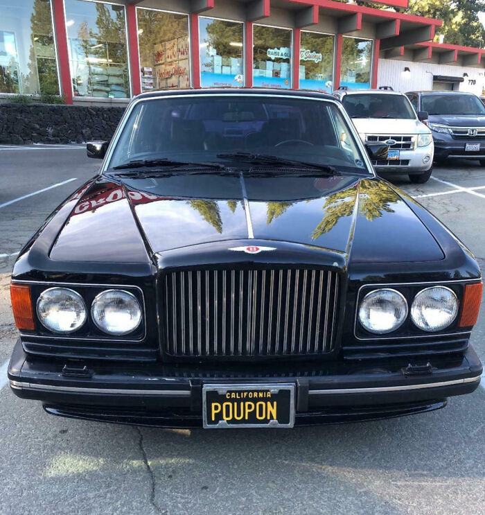 Vintage black car with a personalized California license plate reading POUPON, an example of hilarious personalized license plates.