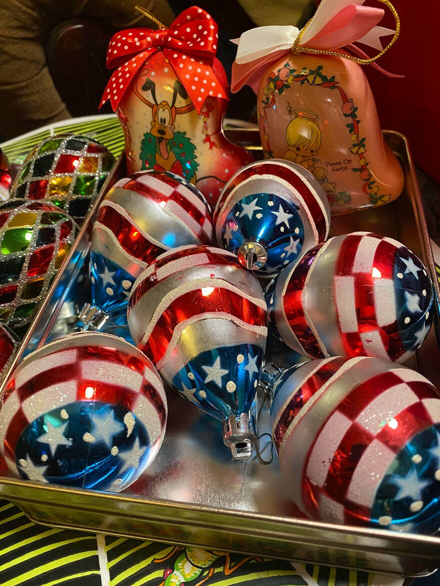 Vintage Christmas decorations featuring patriotic-themed ornaments and character-themed holiday boots in a metal tray.