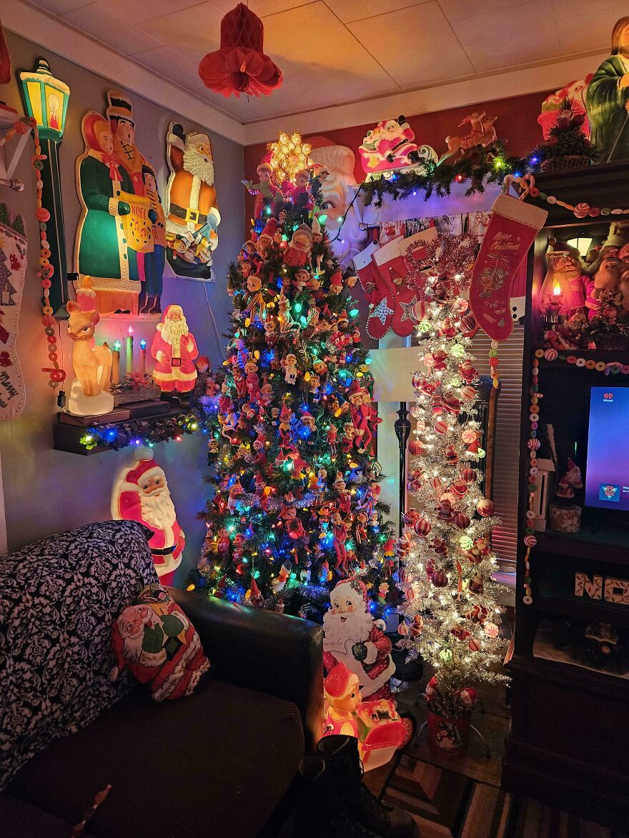 Cozy living room with nostalgic vintage Christmas decorations, colorful lights, and classic holiday ornaments on trees.
