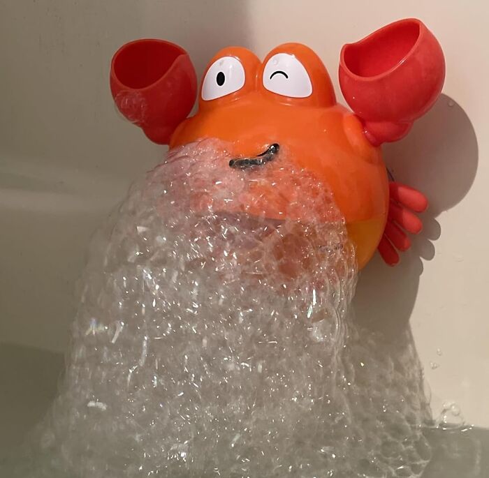 Orange crab bath toy pouring bubbles in a bathtub, a fun gift that unleashes 5-year-old joy and playtime excitement.