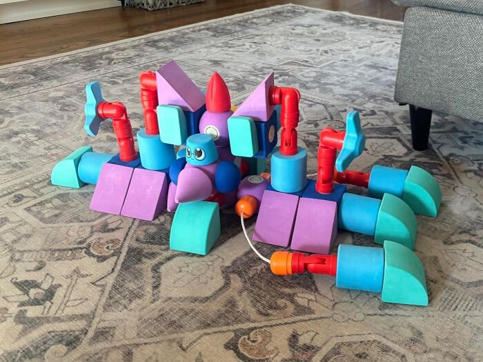 Colorful robot toy made from interlocking blocks on a patterned rug, perfect gifts for 5-year-old joy and playtime.