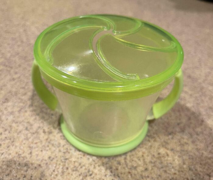 Green snack container with handles on a countertop, illustrating a wholesome funny and goofy dad moment.
