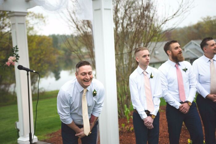 Group of men in dress shirts and ties laughing and posing in funny pics taken at the perfect time outdoors near a lake.