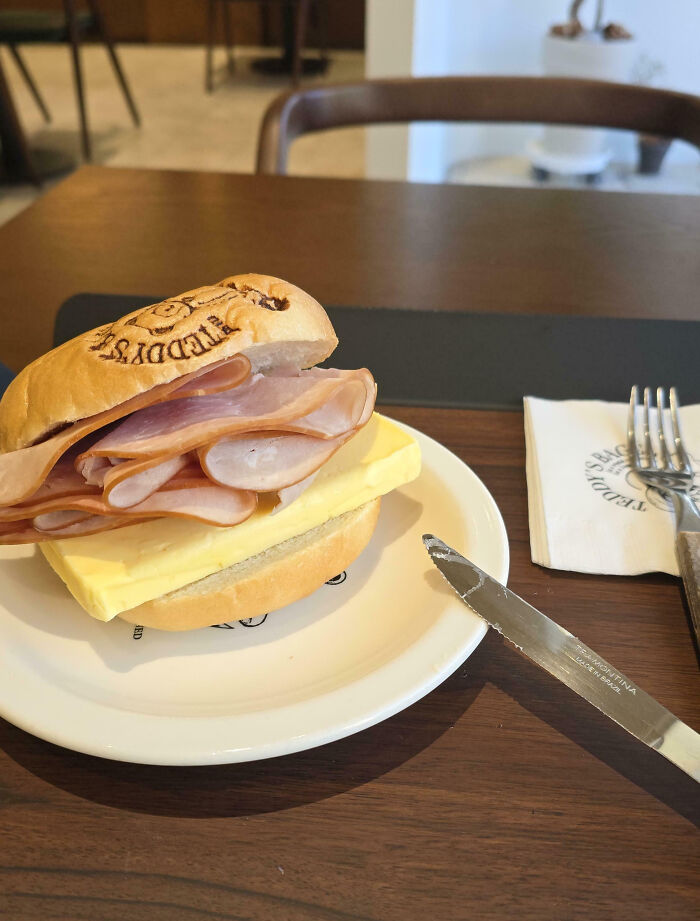 Ham and thick slice of butter sandwich on a plate, an example of outrageous meals that look nothing like menu photos.
