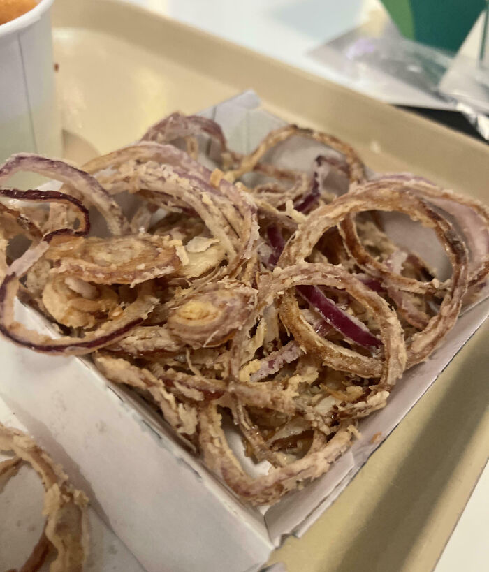 Fried onion rings served in a fast-food tray, an example of outrageous meals that look nothing like menu photos.