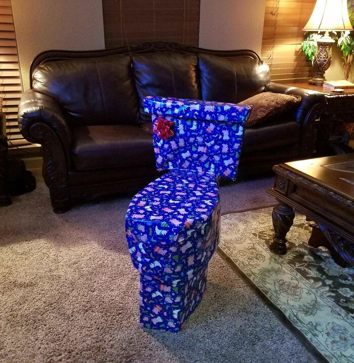 Toilet wrapped in funny Christmas gift wrap with a red bow, blending holiday cheer and mischief inspiration.