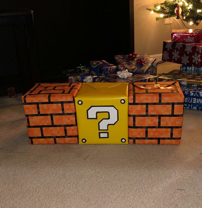 Christmas presents wrapped with funny gift wrap featuring a Super Mario question block and brick pattern design.