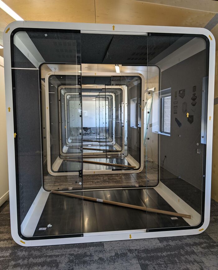 Modern office workspace with glass partitions creating an infinite reflection effect, showcasing unique 9-to-5 jobs.