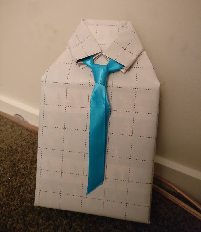 Gift wrap designed to look like a shirt with a blue tie, one of the funniest gift wraps inspiring Christmas mischief.