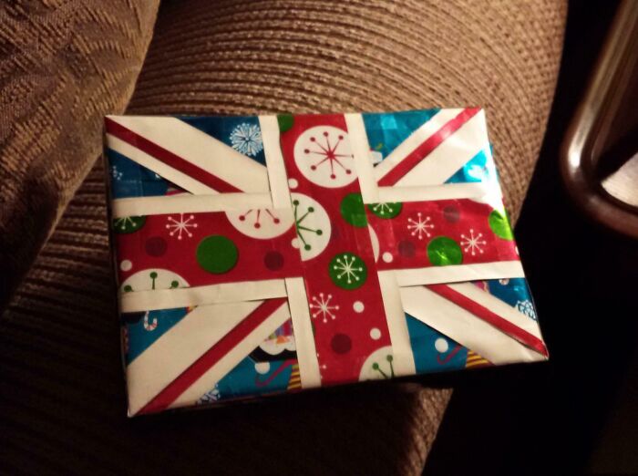 Christmas gift wrapped with funny design using red, white, and blue paper for creative and playful gift wrap inspiration.