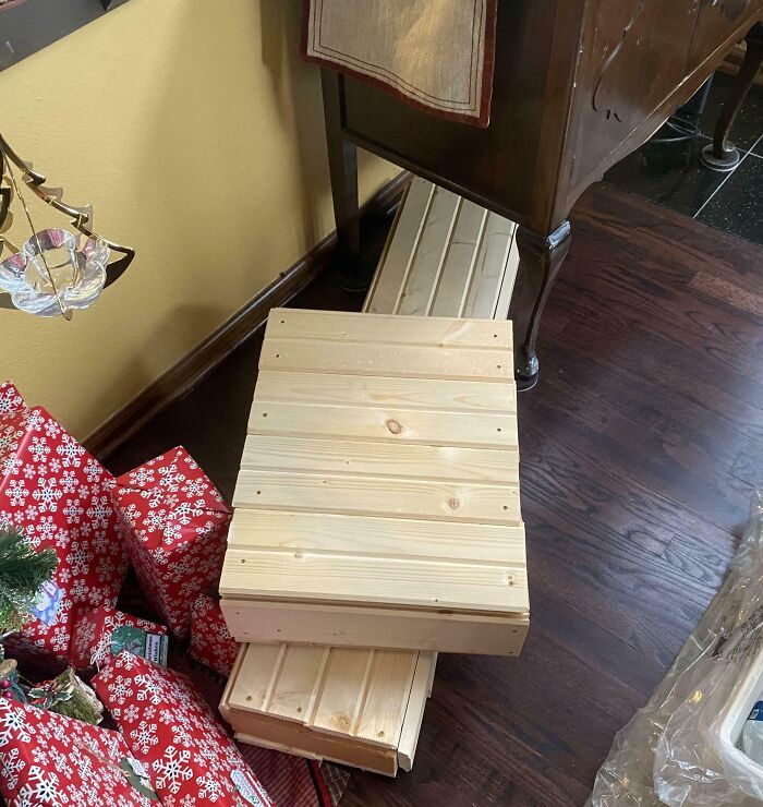 Wooden boxes disguised as wrapped gifts among Christmas presents, showcasing funny gift wraps inspiring holiday mischief.