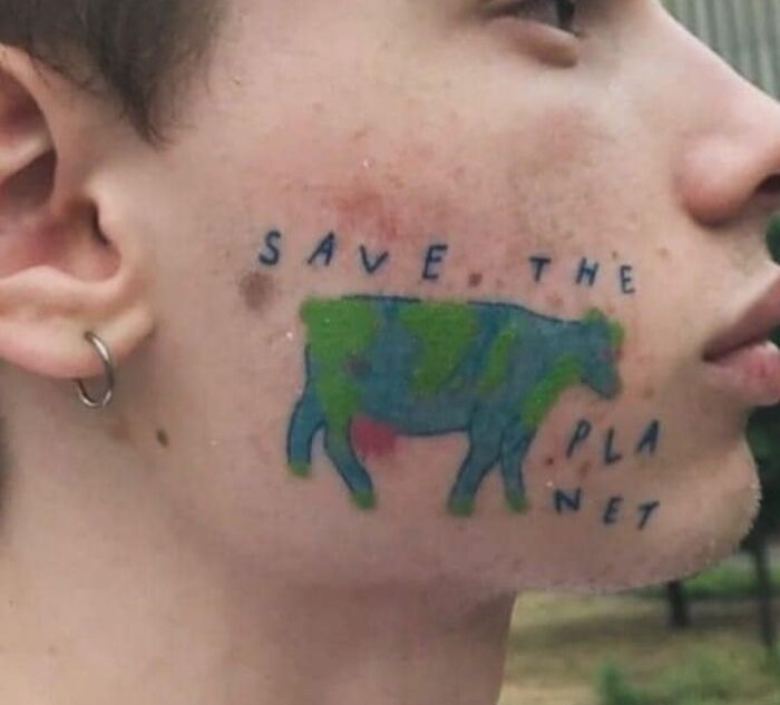 Face tattoo of a poorly drawn cow with the words save the planet, showcasing one of the worst tattoos causing cringe.