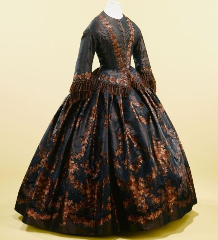 Victorian-era dress with intricate floral patterns showcasing culture and everyday life in the past through old photos.