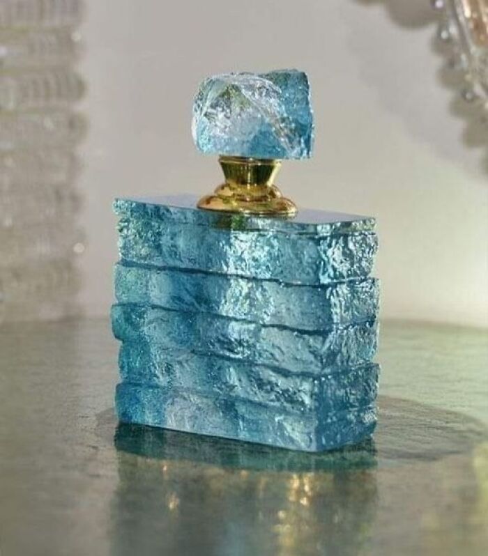 Blue textured glass perfume bottle reflecting culture and everyday life in powerful old photos from the past.