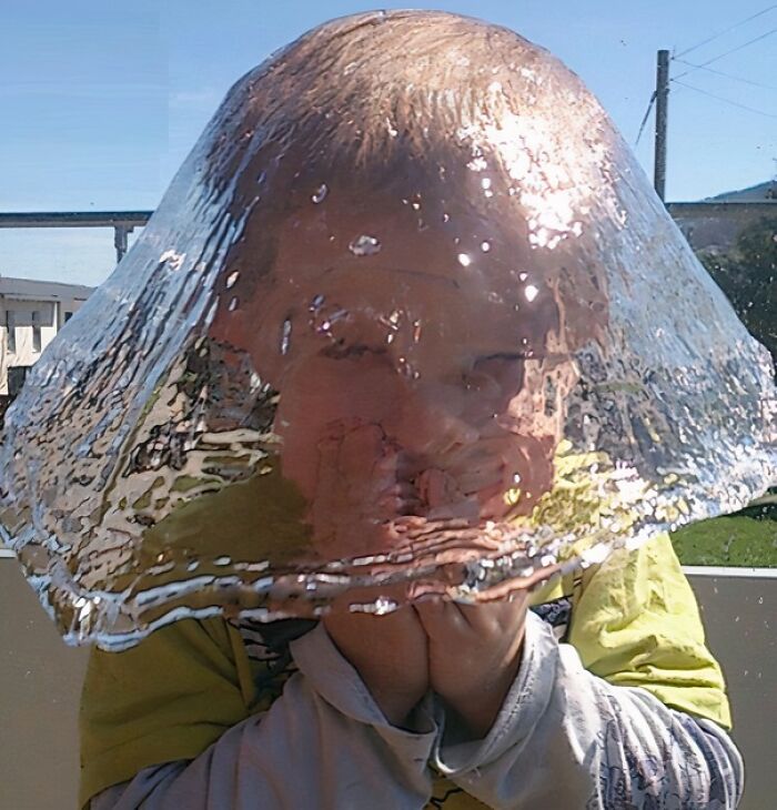 Child frozen inside a bubble of water captured in a funny and interesting perfect timing photo.
