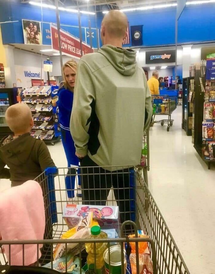 Family shopping inside Walmart with full cart, capturing one of the many pics that show what’s going on in these stores.