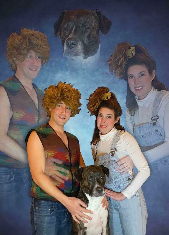 Couple with retro hairstyles posing awkwardly with their dog in a hilariously awkward family Christmas photo.