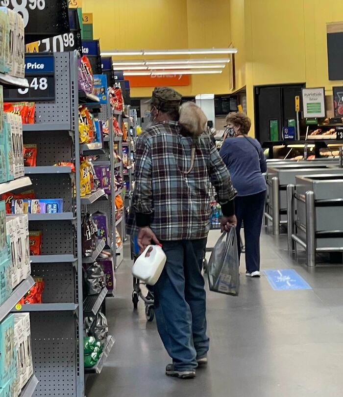 Shoppers browsing aisles with snacks and groceries inside a Walmart store with bright yellow walls and overhead lights.