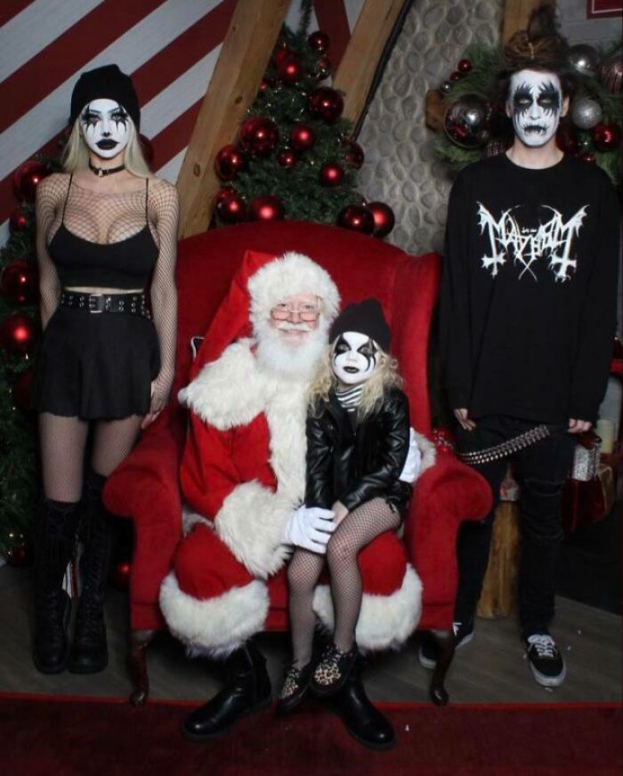 Family Christmas photo with three children in heavy makeup posing with Santa in a funny and awkward holiday setting.