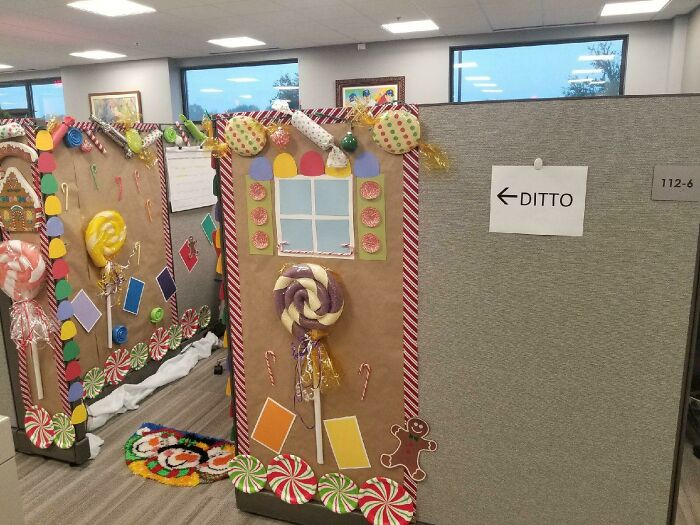 Office cubicles creatively decorated with candy-themed Christmas decorations showcasing impressive workplace holiday spirit.