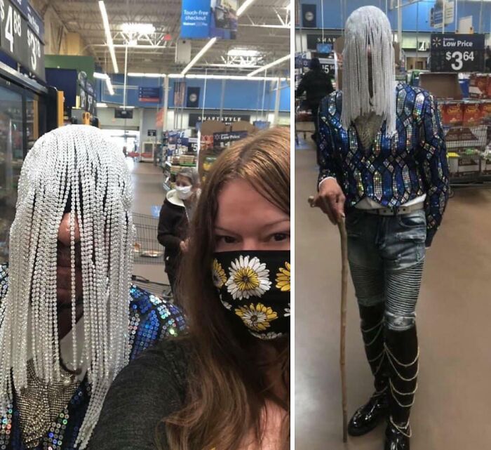 Person wearing a beaded fringe face covering and colorful outfit inside a Walmart store, creating a curious scene.