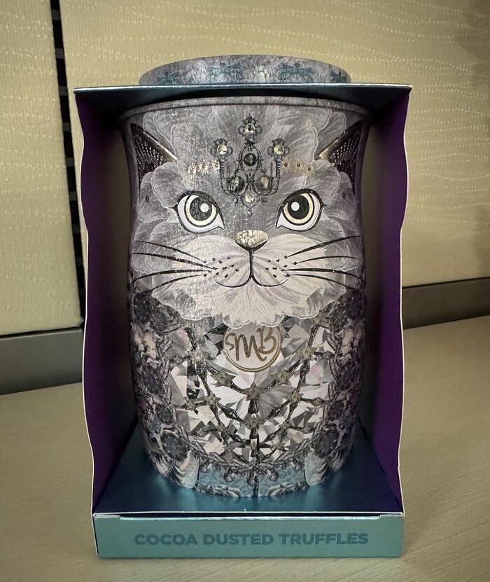 Decorative cat-shaped container of cocoa dusted truffles, a unique gift for the person who has everything.