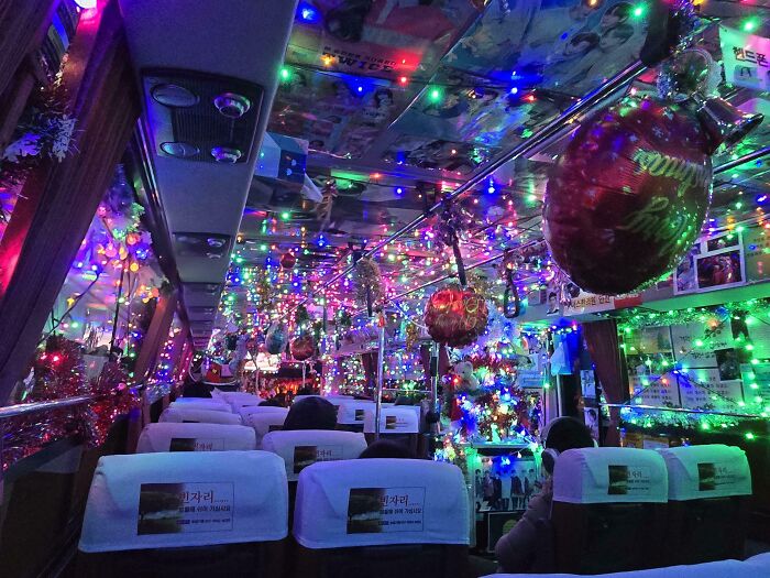 Bus interior decorated with creative Christmas decorations and colorful lights impressing holiday spirit.