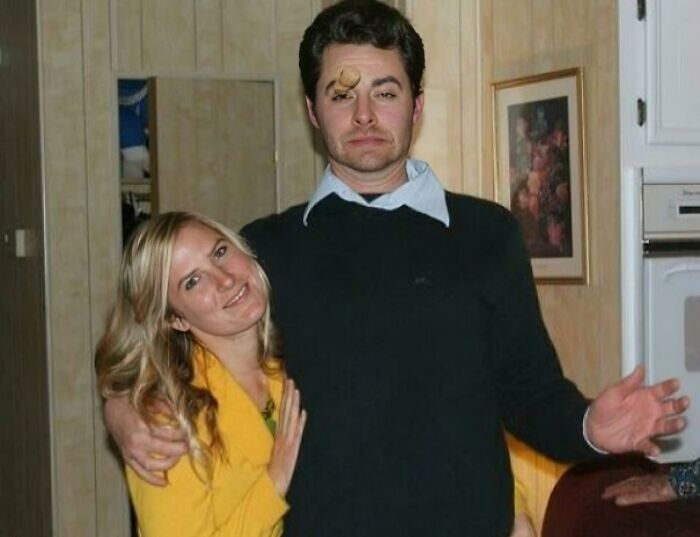 Awkward family Christmas photo with a man making a funny face and a woman smiling, highlighting cringe holiday moments.