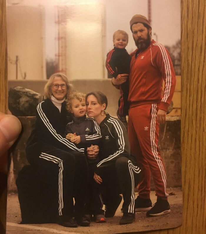 Family dressed in retro matching tracksuits posing awkwardly outdoors in a hilariously awkward family Christmas photo.