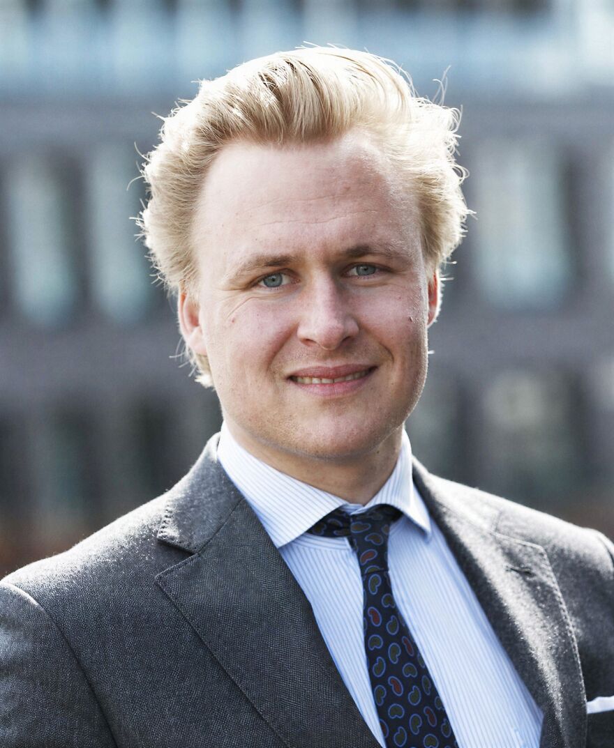 Young man in a suit and tie outdoors representing the idea of the oldest surviving monarchies in the world.