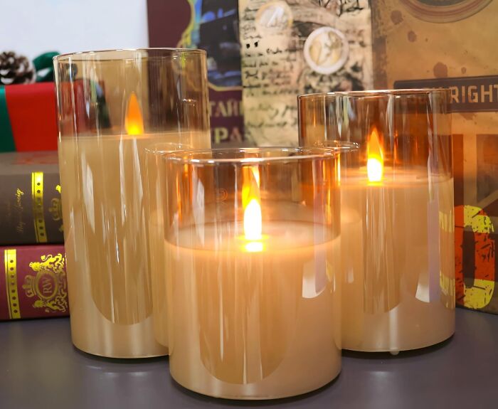 Set of three lit candles with warm flames, ideal unique gifts for the person who has everything and won’t forget it.